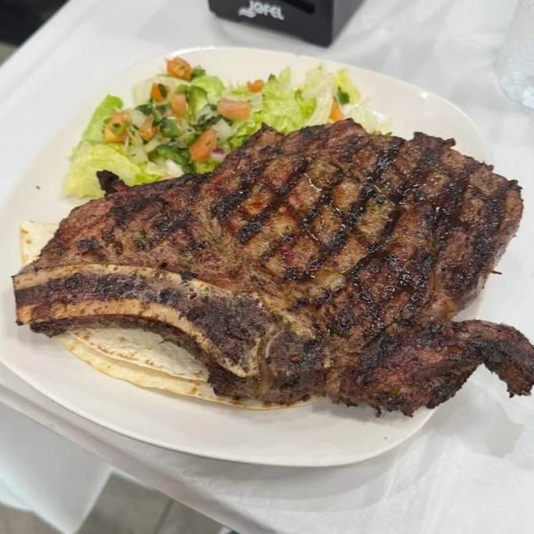 Halal Cuts' grilled steak with bone, served with tortillas and a fresh green salad.
