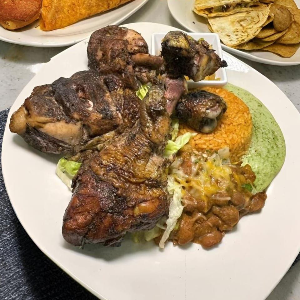 Halal Cuts' grilled chicken with rice, beans, and green sauce, alongside tacos and quesadillas.