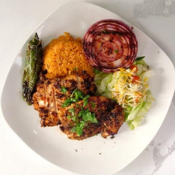 Halal Cuts grilled chicken with rice, grilled onion, jalapeño, and a side salad.