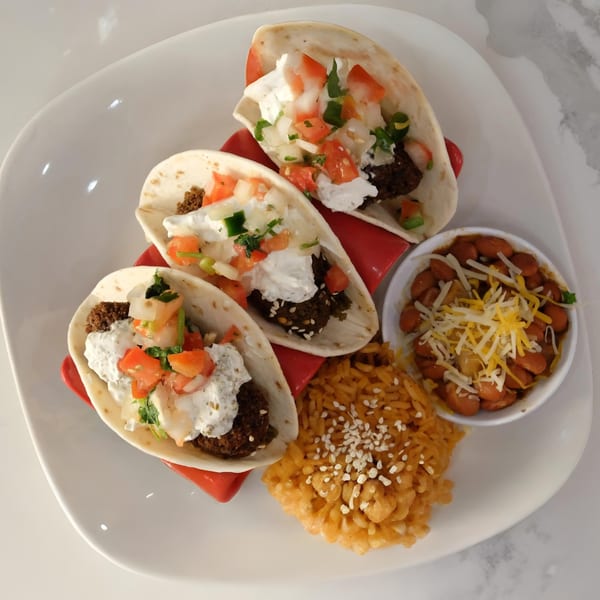 Three Halal Cuts tacos with meat, sour cream, and pico de gallo, served with rice and beans.
